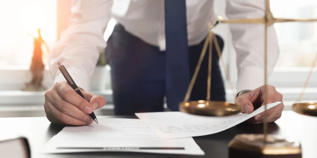 lawyer at desk signing paperwork